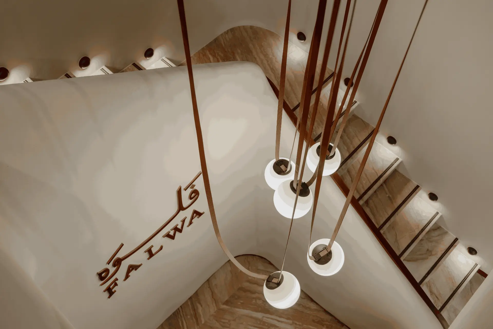 Falwa signage in bronze beside the staircase pendants